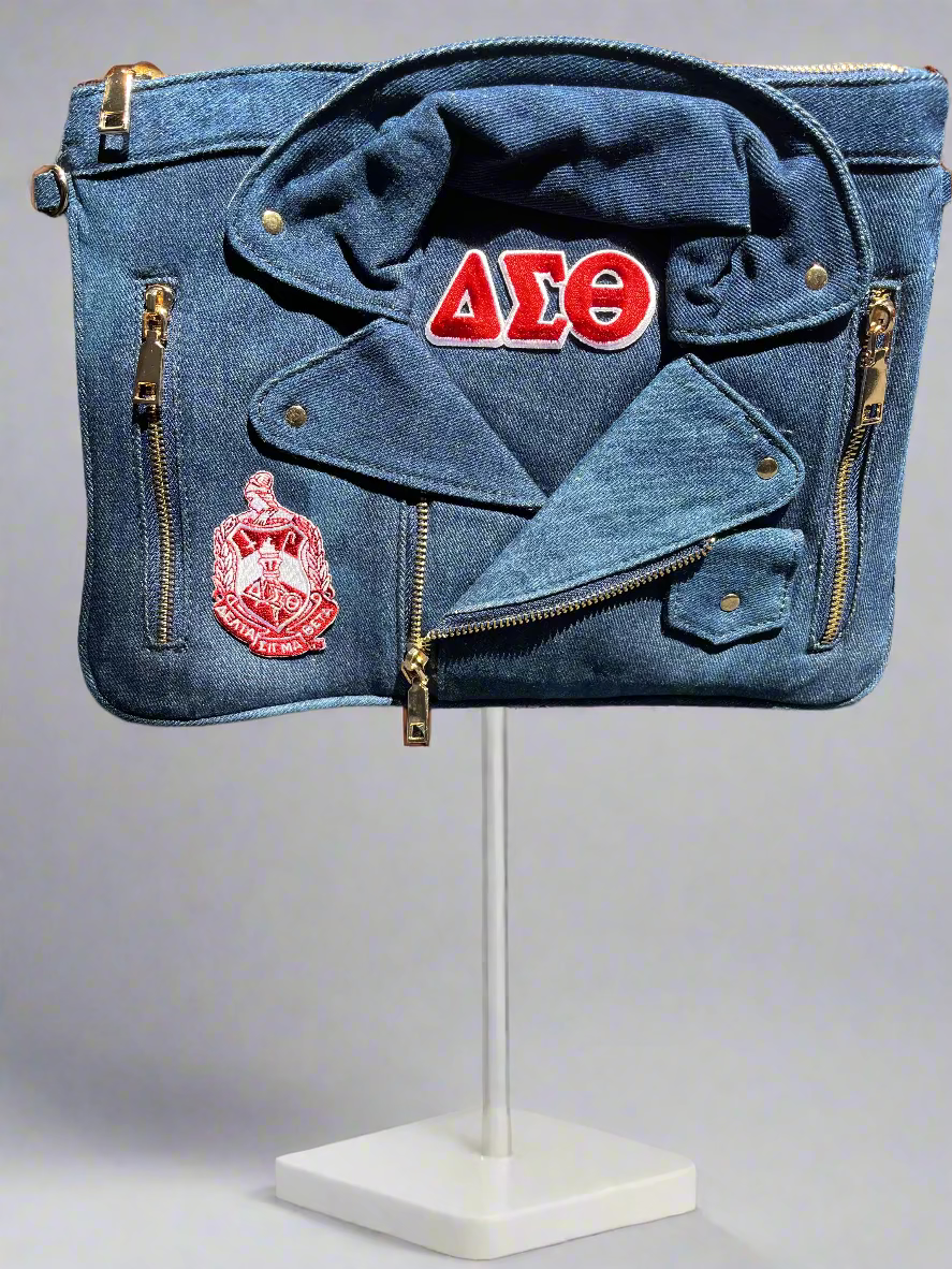 Denim clutch bag featuring the Delta Sigma Theta shield and bold Greek letters. A stylish, durable accessory that combines classic denim with sorority pride perfect for events, casual outings, or stepping out in Delta style.