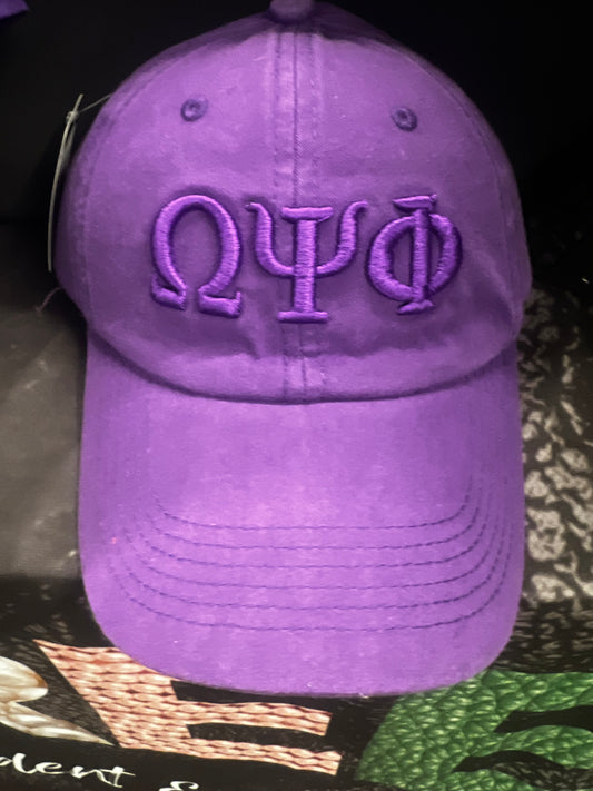 Purple Omega Psi Phi snapback with embroidered letters on a dark background