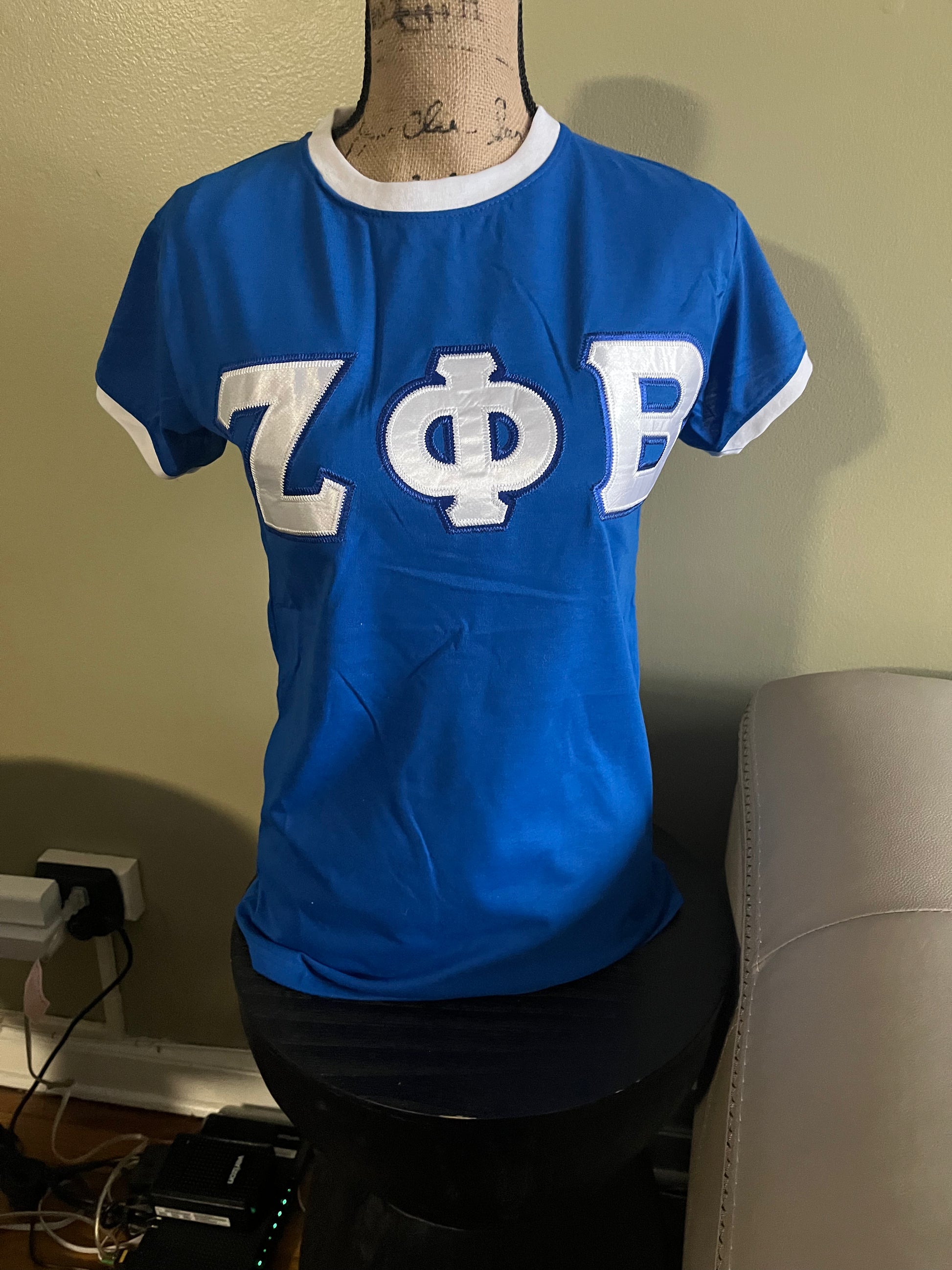 Classic Zeta Phi Beta traditional tee designed for everyday Greek pride. Made with minimal stretch for a structured fit recommended to size up for the best comfort. Perfect for casual wear, chapter events, or showing off your Zeta spirit in a clean, timeless style.