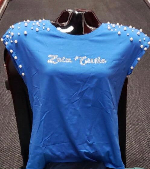 Stay cute and classy in the Zeta Cutie Shirt, designed with cap sleeves accented by elegant pearls along the shoulders. This top run slightly small, with the largest fit up to size 20 perfect for a polished, feminine Soror look.