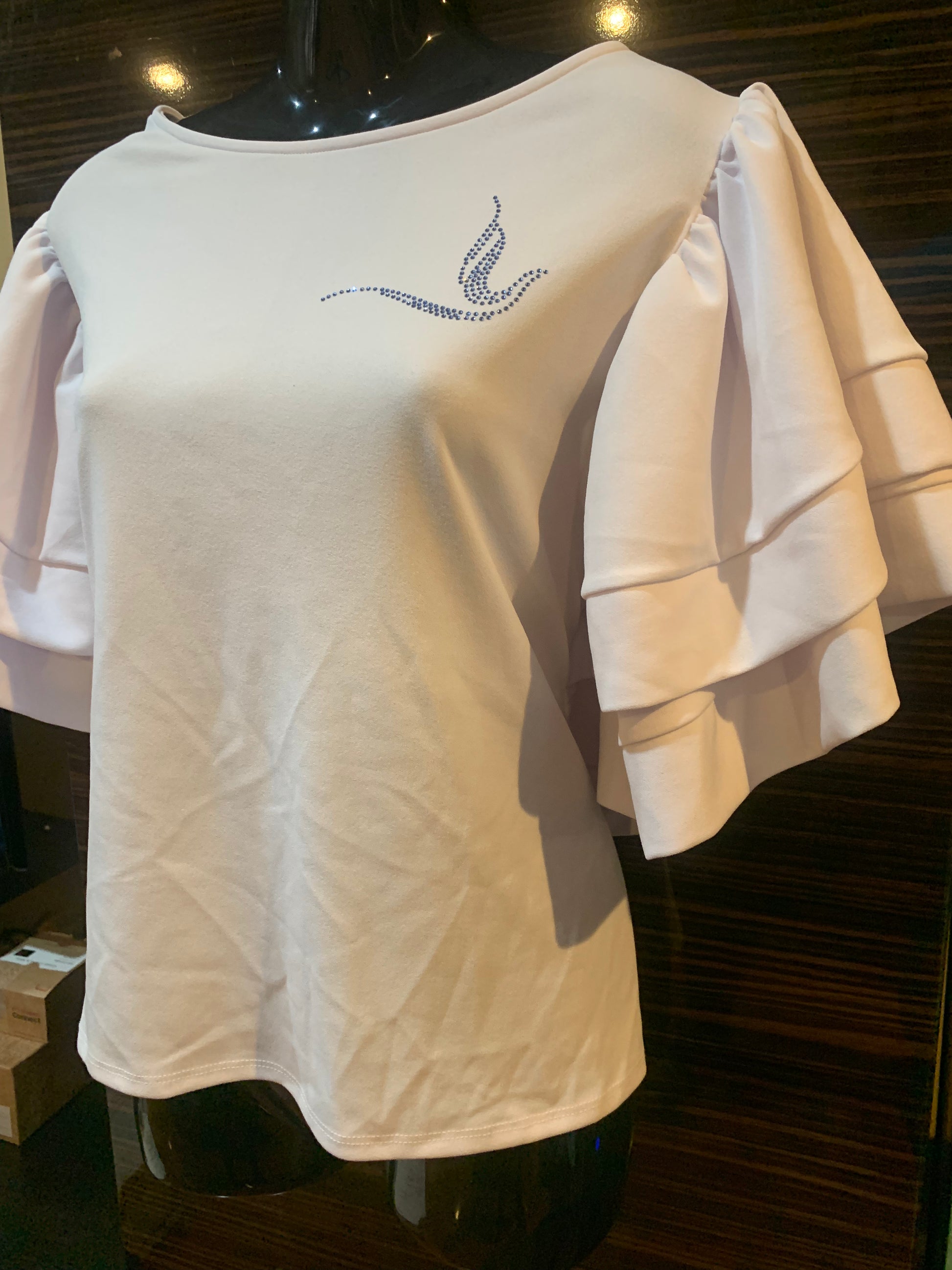 Celebrate your Zeta Phi Beta pride with the Doved and Stoned blouse. This all-white blouse features elegant, ruffled sleeves for a sophisticated touch and a sparkling stoned Dove emblem over the heart to showcase your Soror spirit. Perfect for events, meetings, or casual outings, this blouse combines timeless style with a statement of pride and elegance.