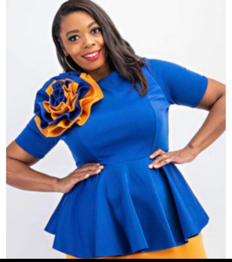 Royal blue peplum blouse with a decorative gold and blue rose accent. Elegant and stylish with a flattering fit.