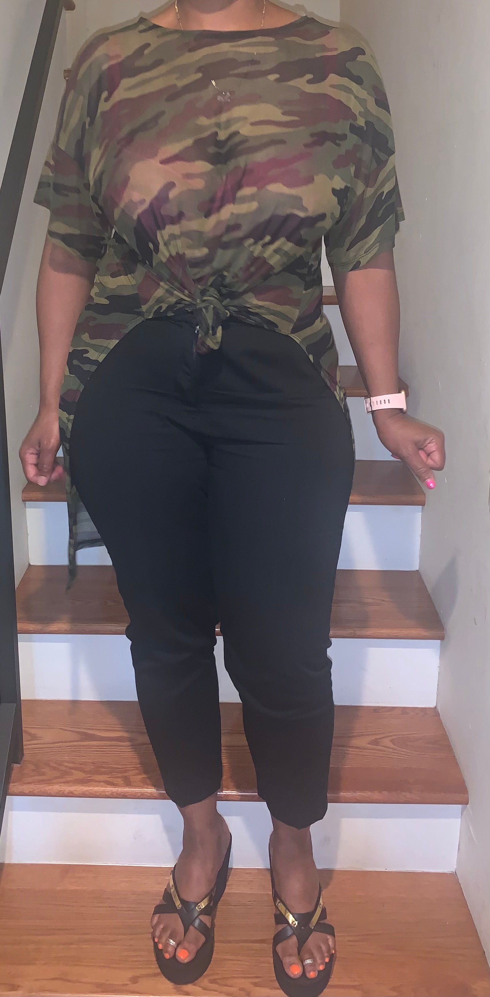 Sheer camouflage high-low top featuring short sleeves and a front tie detail. 